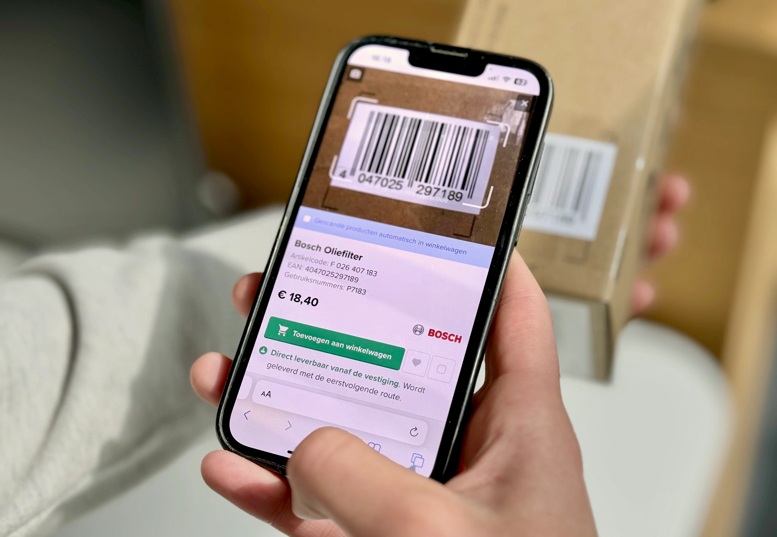 A phone scanning the barcode on a parts box, the scanned oil filter ready to add to the cart